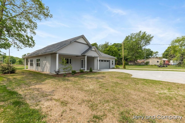 2076 W Lakewood Blvd, Holland, MI 49424 - view of front facade with concrete driveway, an attached garage, and a front lawn