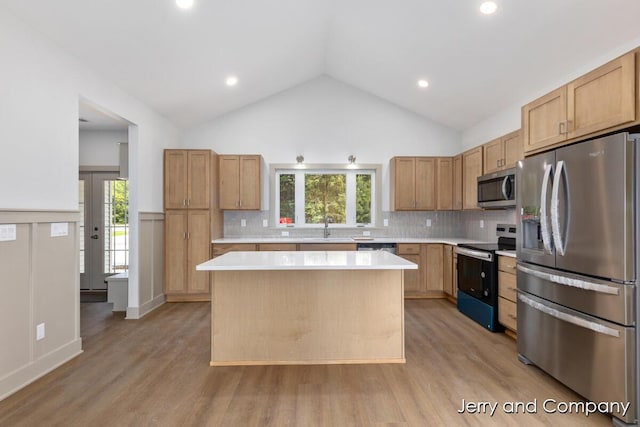 2076 W Lakewood Blvd, Holland, MI 49424 - kitchen featuring stainless steel appliances, light countertops, a sink, light wood-type flooring, and lofted ceiling
