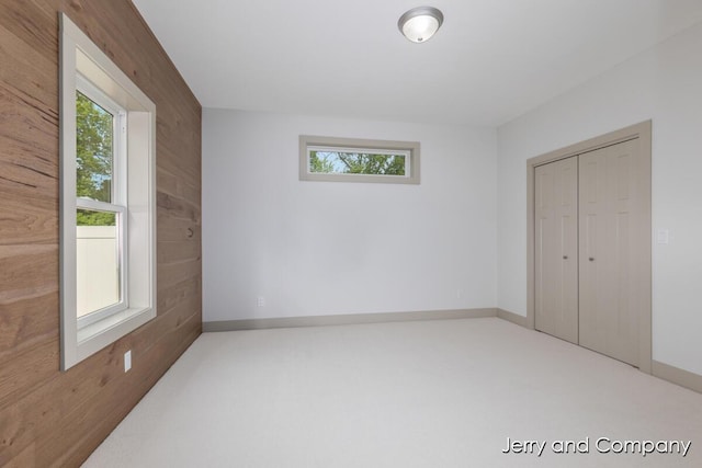 2076 W Lakewood Blvd, Holland, MI 49424 - unfurnished bedroom featuring wood walls, a closet, carpet, and baseboards