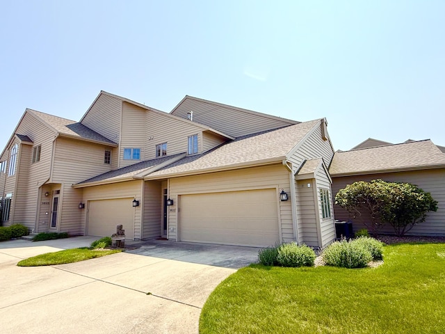 3633 Marina View Pt, Muskegon, MI 49441 - view of front of house featuring an attached garage, concrete driveway, a front yard, and roof with shingles