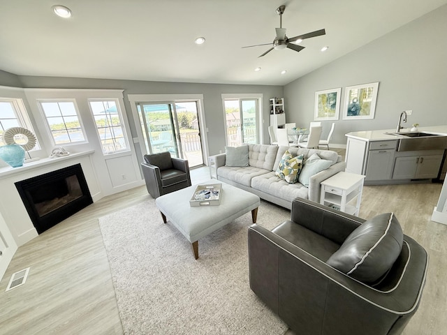3633 Marina View Pt, Muskegon, MI 49441 - living room featuring light wood finished floors, a glass covered fireplace, recessed lighting, ceiling fan, and vaulted ceiling