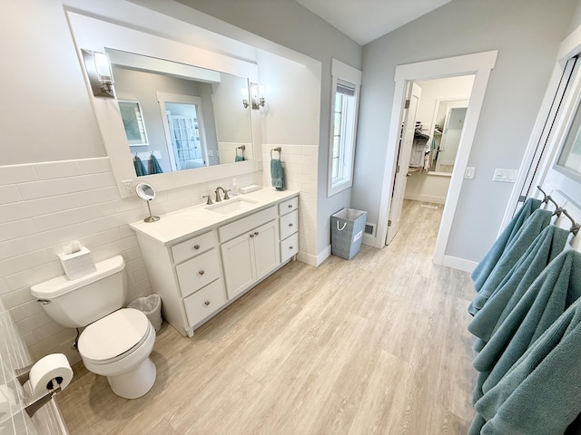 3633 Marina View Pt, Muskegon, MI 49441 - bathroom featuring tile walls, wood finished floors, vanity, toilet, and wainscoting
