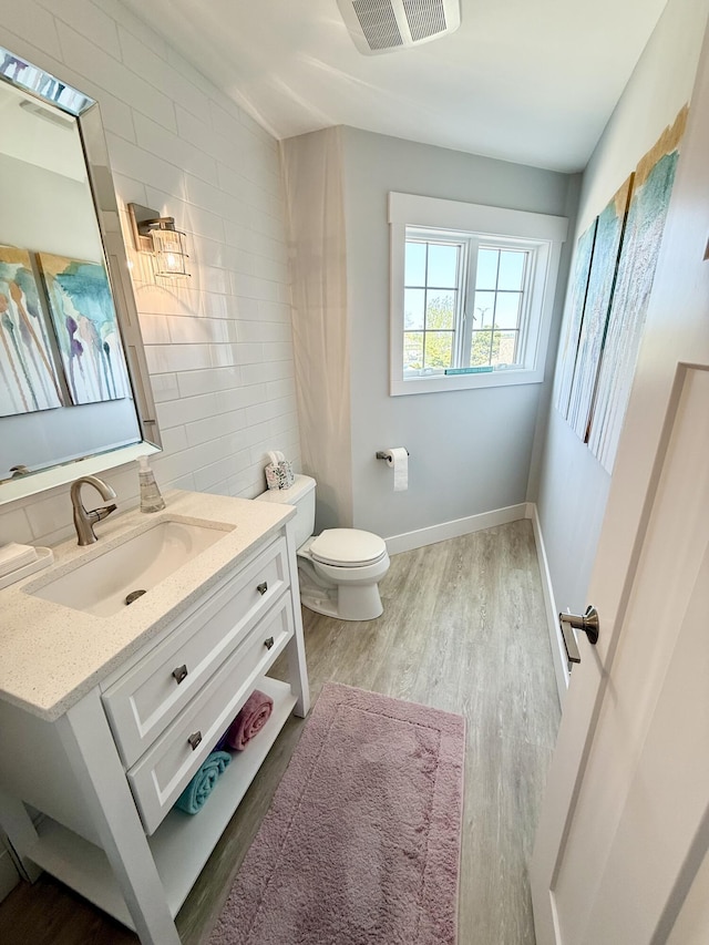 3633 Marina View Pt, Muskegon, MI 49441 - bathroom featuring wood finished floors, toilet, vanity, and baseboards