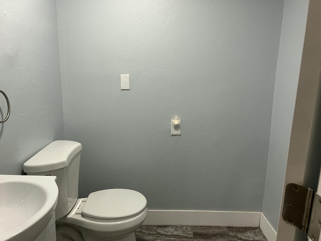 1283 Vesta Rd, Muskegon, MI 49445 - bathroom with toilet, baseboards, and vanity