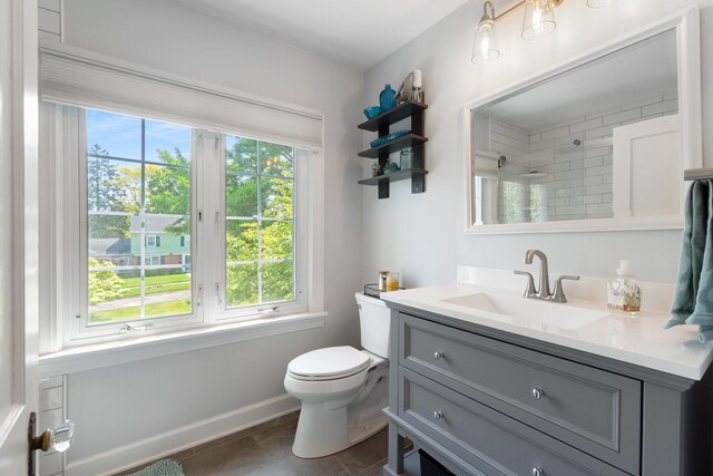770 Bloomfield Blvd, Jackson, MI 49203 - bathroom featuring vanity, toilet, tiled shower, tile patterned flooring, and baseboards