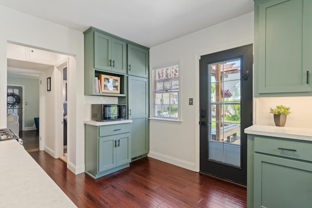 770 Bloomfield Blvd, Jackson, MI 49203 - kitchen featuring green cabinets, light countertops, dark wood finished floors, baseboards, and backsplash
