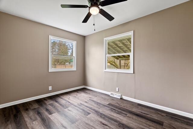 507 E 4th St, Hersey, MI 49639 - spare room featuring dark wood-style flooring, baseboards, and ceiling fan