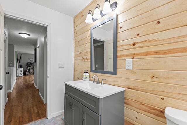 507 E 4th St, Hersey, MI 49639 - half bath with wooden walls, vanity, toilet, and baseboards