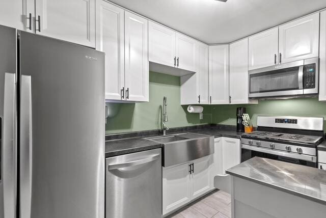 507 E 4th St, Hersey, MI 49639 - kitchen with appliances with stainless steel finishes, a sink, white cabinets, and light wood finished floors