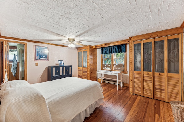 8661 Elm Valley Rd, Union Pier, MI 49129 - bedroom featuring wood-type flooring, multiple windows, a textured ceiling, two closets, and ceiling fan