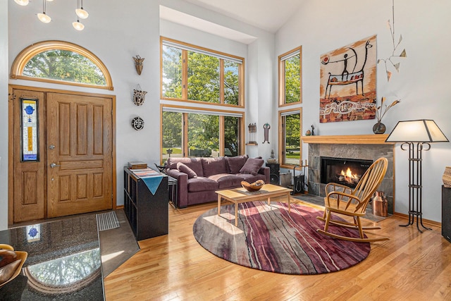 4223 Spring Lake Blvd, Ann Arbor, MI 48108 - living room with high vaulted ceiling, healthy amount of natural light, a glass covered fireplace, hardwood / wood-style flooring, and baseboards