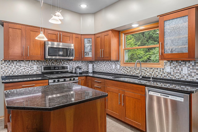 4223 Spring Lake Blvd, Ann Arbor, MI 48108 - kitchen with appliances with stainless steel finishes, a sink, brown cabinets, dark stone countertops, and hanging light fixtures