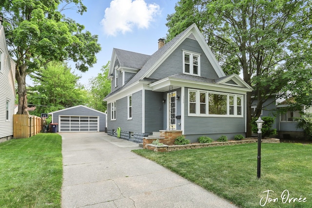 120 E 19th St, Holland, MI 49423 - view of front of property featuring an outbuilding, a detached garage, roof with shingles, and a chimney