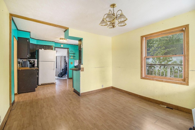 302 Wood St, Hart, MI 49420 - unfurnished room with a chandelier, light wood finished floors, and baseboards