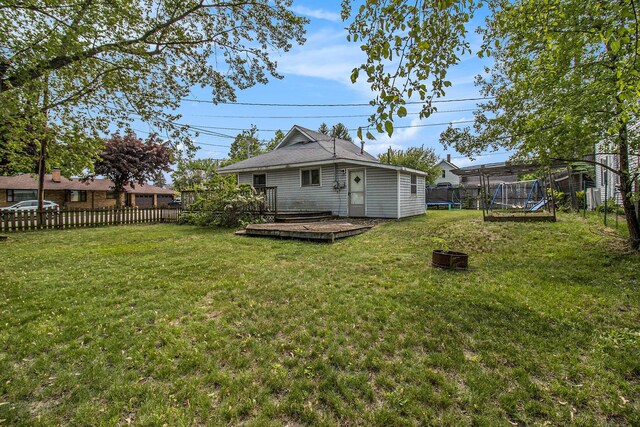 302 Wood St, Hart, MI 49420 - rear view of property with a trampoline and a wooden deck