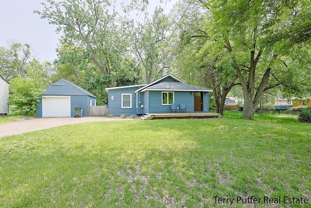 987 Oak Ave, Muskegon, MI 49442 - view of front of property with a detached garage, driveway, a deck, an outdoor structure, and view of wooded area
