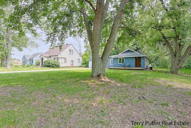 987 Oak Ave, Muskegon, MI 49442 - view of front of house with a front yard and a deck