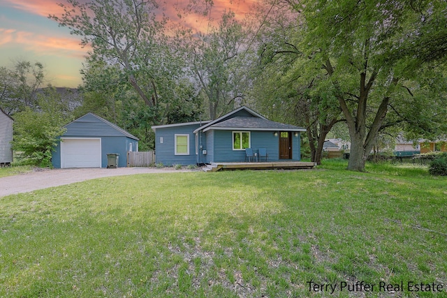 987 Oak Ave, Muskegon, MI 49442 - view of front of house with a detached garage, driveway, a deck, and an outbuilding