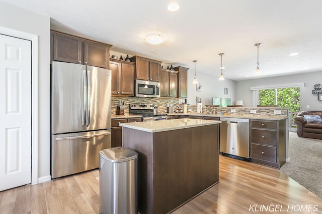 926 N Sandalwood Cir, Muskegon, MI 49441 - kitchen with appliances with stainless steel finishes, a peninsula, open floor plan, light wood-type flooring, and a center island