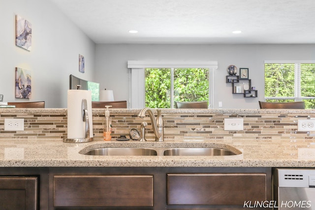 926 N Sandalwood Cir, Muskegon, MI 49441 - kitchen with stainless steel dishwasher, backsplash, a sink, dark brown cabinets, and recessed lighting