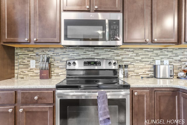 926 N Sandalwood Cir, Muskegon, MI 49441 - kitchen with appliances with stainless steel finishes, backsplash, and light stone countertops