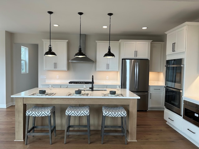 4846 W Burton Ln Unit 22, Saline, MI 48176 - kitchen featuring appliances with stainless steel finishes, wall chimney range hood, light countertops, a kitchen bar, and recessed lighting
