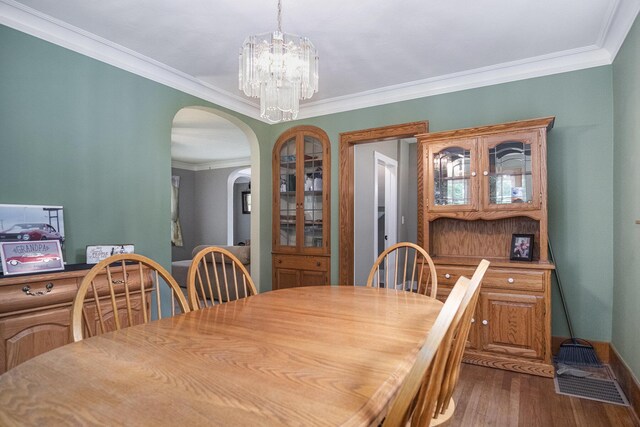 3544 Briggs Blvd NE, Grand Rapids, MI 49525 - dining space with a chandelier, ornamental molding, dark wood finished floors, arched walkways, and baseboards