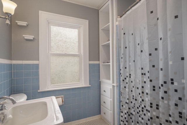 3544 Briggs Blvd NE, Grand Rapids, MI 49525 - bathroom with tile walls, a sink, curtained shower, wainscoting, and tile patterned flooring