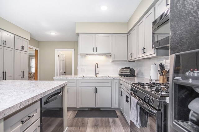 3544 Briggs Blvd NE, Grand Rapids, MI 49525 - kitchen with black appliances, a sink, dark wood-style flooring, backsplash, and gray cabinetry