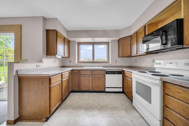 2045 E Baldwin Rd, Grand Blanc, MI 48439 - kitchen featuring white appliances, a sink, brown cabinets, and a peninsula