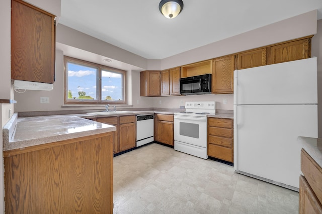 2045 E Baldwin Rd, Grand Blanc, MI 48439 - kitchen featuring white appliances, a sink, light countertops, brown cabinetry, and light floors