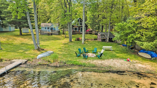 1142 Wolf Lake Dr, Baldwin, MI 49304 - view of green lawn with a fire pit and a wooden deck