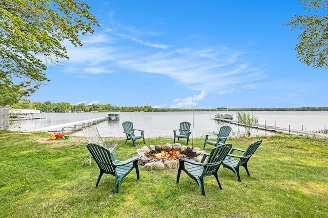 1142 Wolf Lake Dr, Baldwin, MI 49304 - view of green lawn with an outdoor fire pit, a water view, and a boat dock