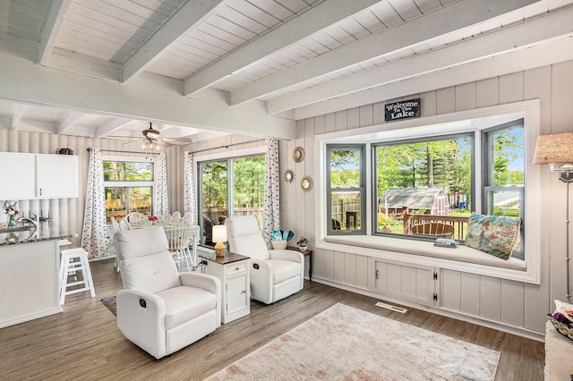 1142 Wolf Lake Dr, Baldwin, MI 49304 - sitting room featuring a ceiling fan, wood finished floors, beam ceiling, and wood walls