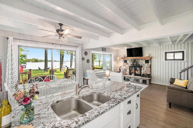 1142 Wolf Lake Dr, Baldwin, MI 49304 - kitchen with open floor plan, beam ceiling, wood finished floors, a sink, and white cabinets