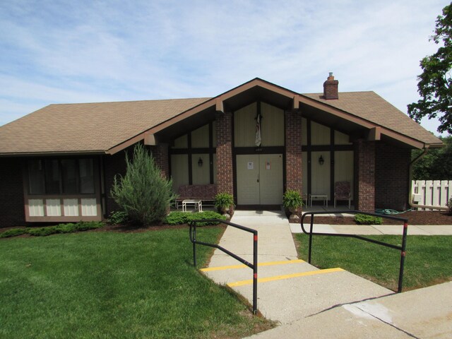 9920 Cambridge Ct, South Lyon, MI 48178 - mid-century home featuring brick siding, a chimney, a front yard, and roof with shingles