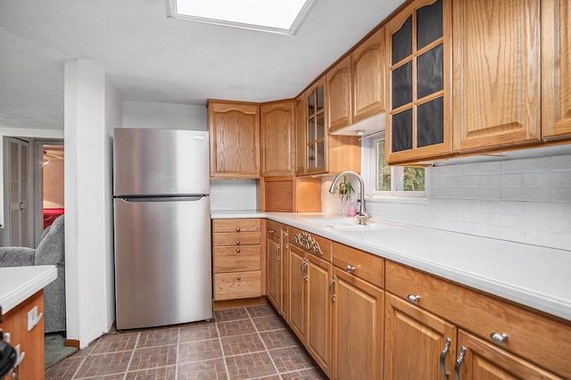 4468 Teal Ln, Newaygo, MI 49337 - kitchen with freestanding refrigerator, a sink, tasteful backsplash, light countertops, and brown cabinets