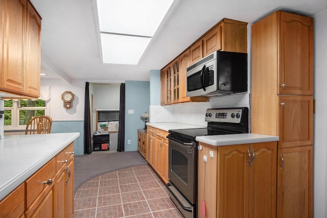 4468 Teal Ln, Newaygo, MI 49337 - kitchen featuring stainless steel appliances, light countertops, glass insert cabinets, light colored carpet, and brown cabinets