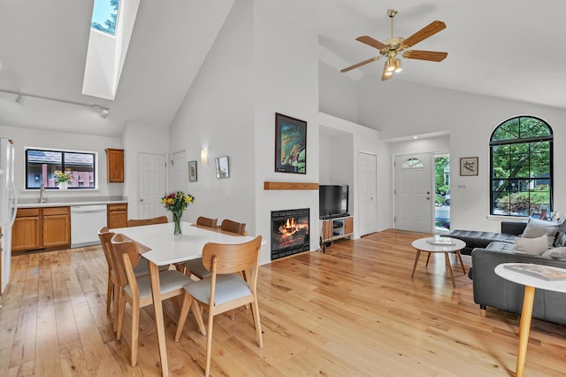 2539 Country Village Ct, Ann Arbor, MI 48103 - dining area with high vaulted ceiling, light wood finished floors, a glass covered fireplace, plenty of natural light, and track lighting