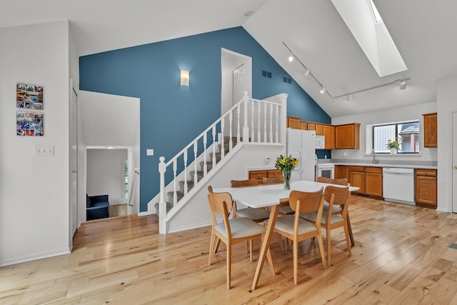 2539 Country Village Ct, Ann Arbor, MI 48103 - dining space with a skylight, stairway, high vaulted ceiling, light wood-style floors, and track lighting