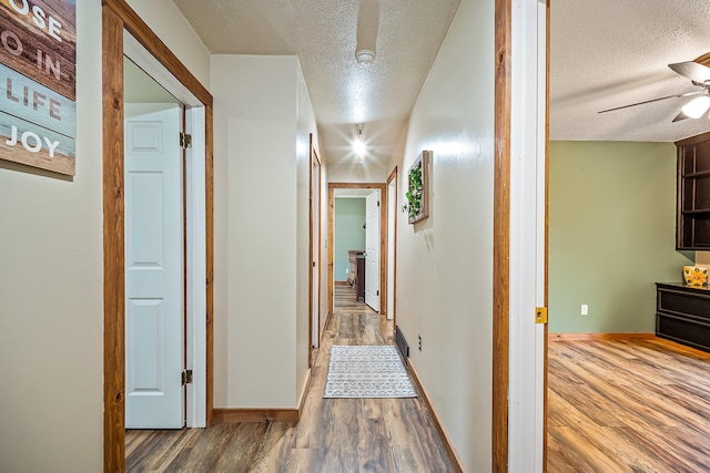 4744 Sandy Ln, Whitehall, MI 49461 - hallway featuring a textured ceiling, wood finished floors, and baseboards