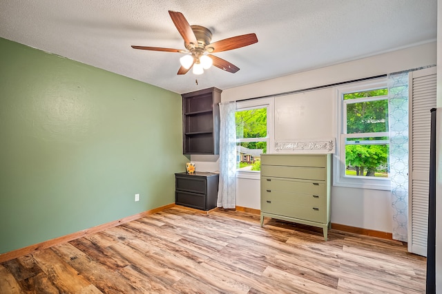 4744 Sandy Ln, Whitehall, MI 49461 - bedroom with multiple windows, a textured ceiling, light wood-style flooring, and baseboards
