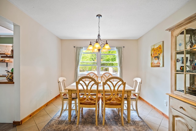 4744 Sandy Ln, Whitehall, MI 49461 - dining area with a chandelier, light tile patterned flooring, a textured ceiling, and baseboards