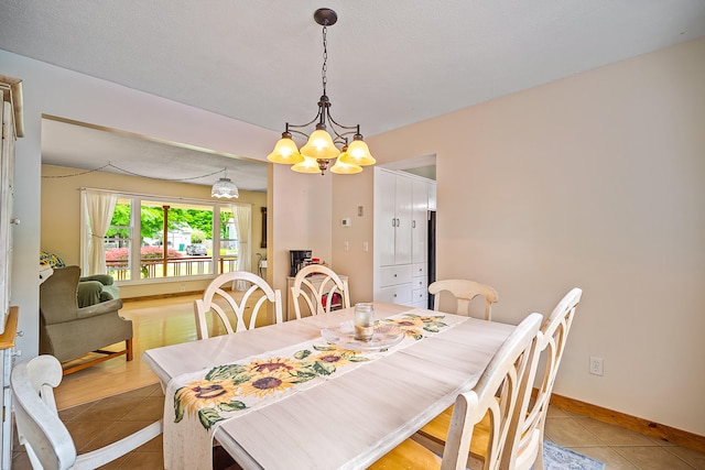 4744 Sandy Ln, Whitehall, MI 49461 - dining room with light tile patterned flooring, a chandelier, and baseboards