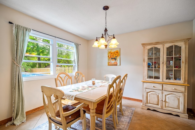 4744 Sandy Ln, Whitehall, MI 49461 - dining room featuring light tile patterned floors, a chandelier, baseboards, and a textured ceiling