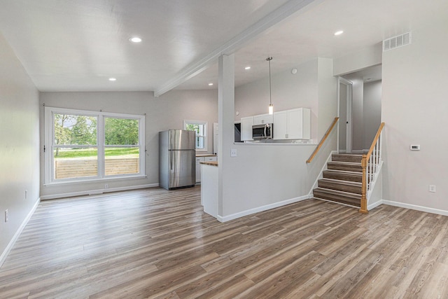 1335 Knapp St NE, Grand Rapids, MI 49505 - unfurnished living room with light wood-style floors, baseboards, recessed lighting, stairway, and lofted ceiling