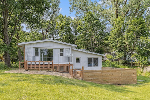 1335 Knapp St NE, Grand Rapids, MI 49505 - back of house featuring a wooden deck, brick siding, and view of wooded area