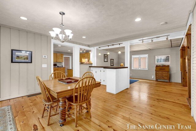 7120 Quarterline Rd, Spring Lake, MI 49456 - dining room featuring light wood finished floors, a chandelier, and a decorative wall