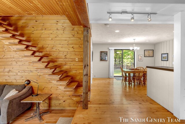 7120 Quarterline Rd, Spring Lake, MI 49456 - staircase featuring wood-type flooring, a chandelier, and wood walls