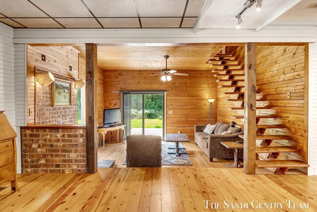 7120 Quarterline Rd, Spring Lake, MI 49456 - living room with light wood finished floors, wood walls, and a ceiling fan